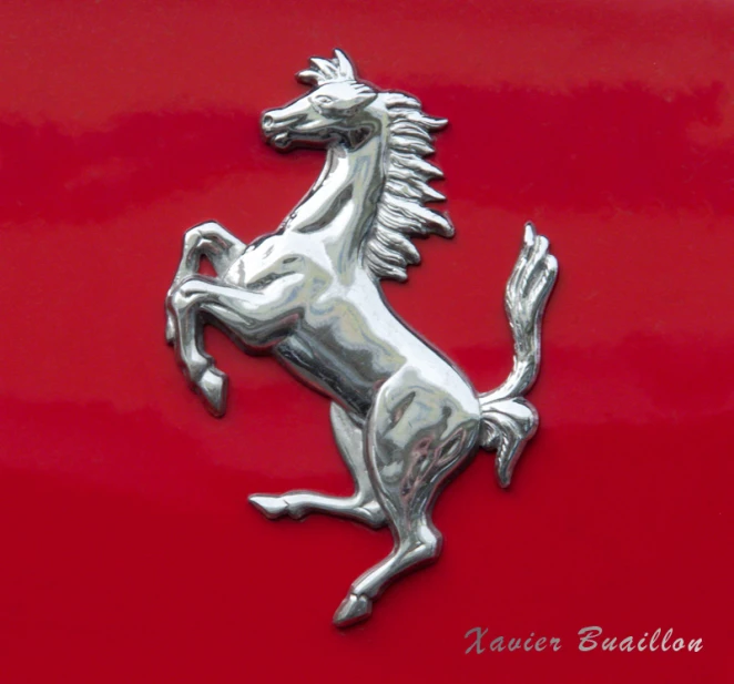 the front end of a red car with a horse