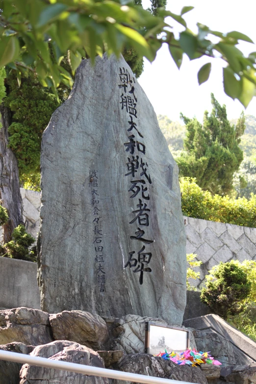 an interesting memorial surrounded by rocks is in a park