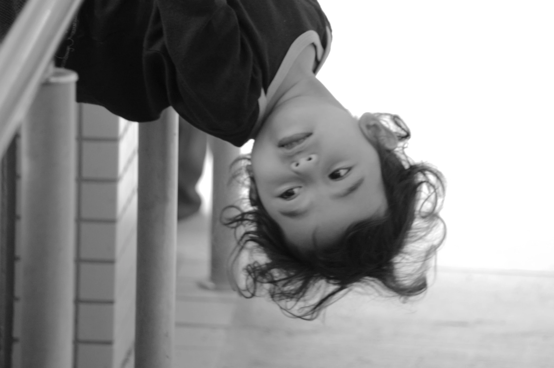 a little girl with long black hair is upside down