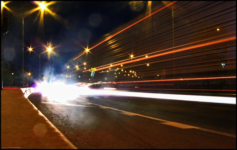 some lights are glowing while the cars are traveling down the street