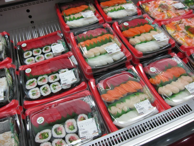 assortment of sushi in plastic containers displayed on shelf