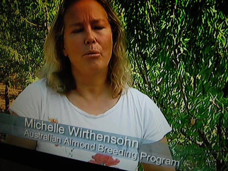 the woman is watching a television screen and making a face