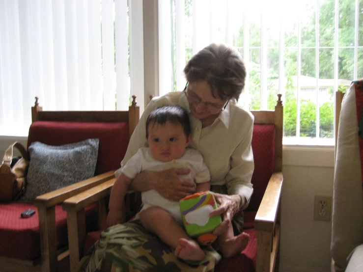 an older woman holding a child in her lap