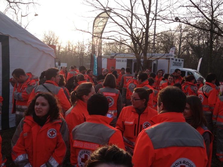 a group of people in orange vests walking in front of a truck