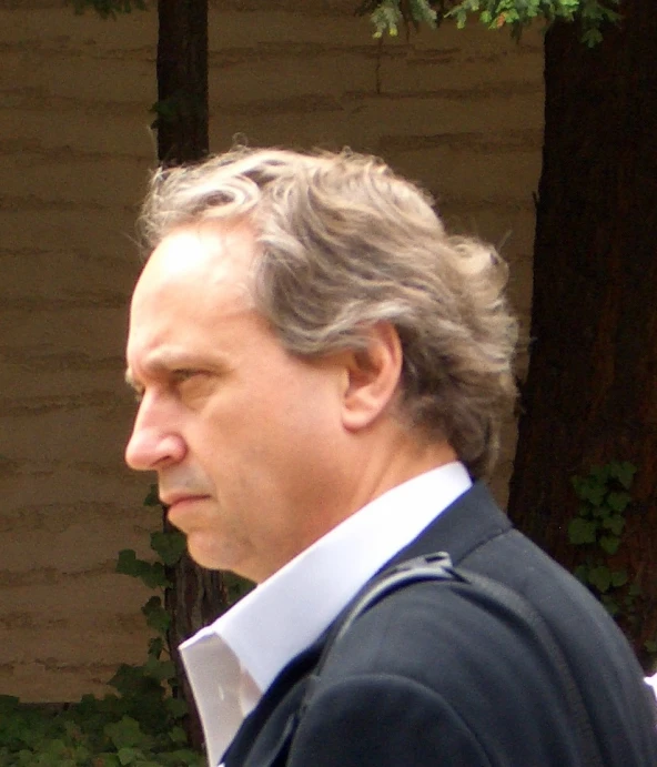 a man in a suit walking through the woods