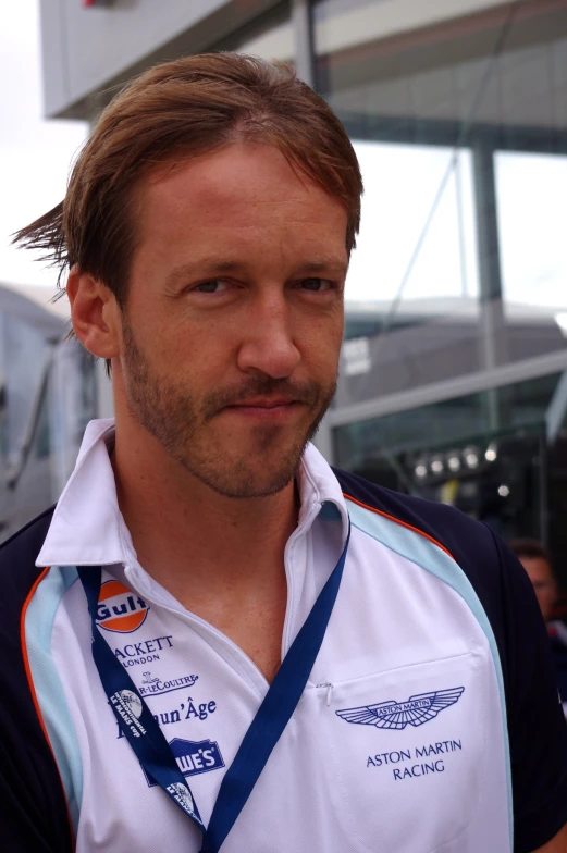 a man wearing a white shirt and blue ribbon around his neck