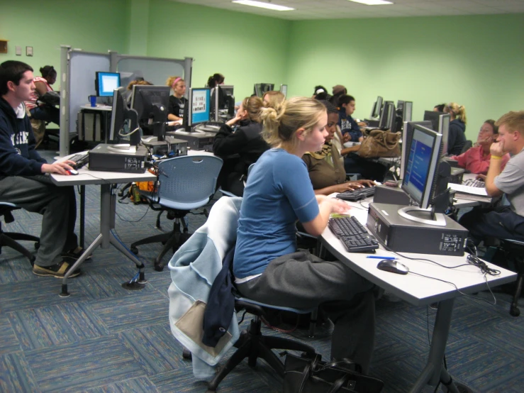 people in a room with computers and people sitting around