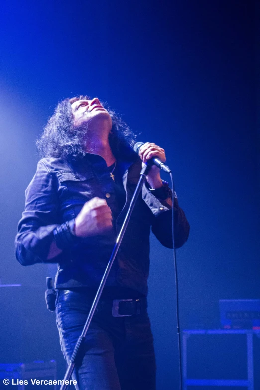 a man in black shirt on stage singing