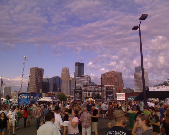 people are walking around a city street with some tall buildings