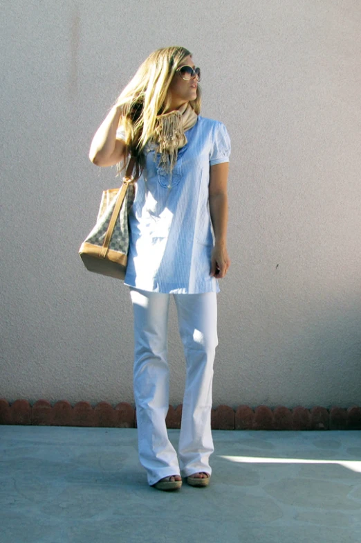 a woman in jeans and top holding a purse