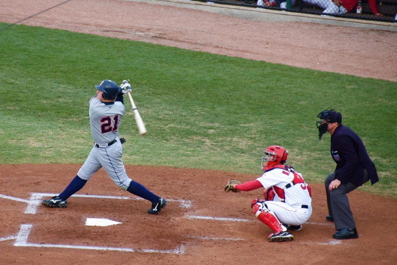 a man swinging a baseball bat on top of a field