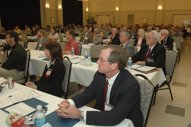 a group of people sitting at tables during a business meeting