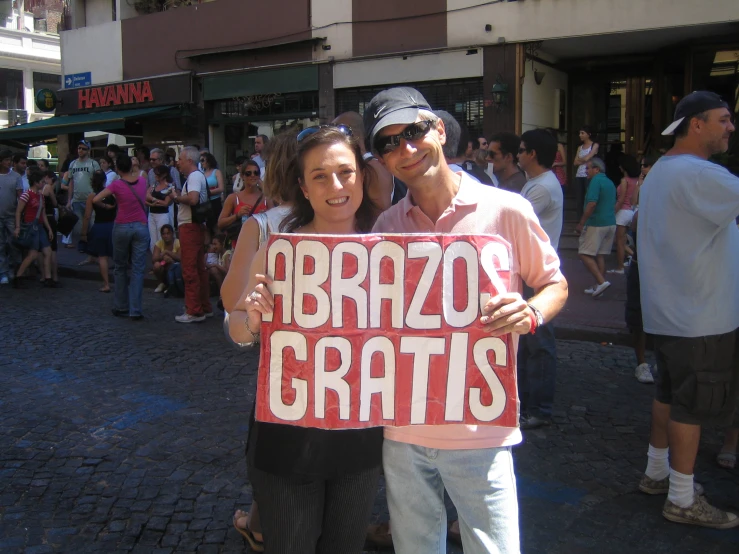 a man and woman standing holding up a sign
