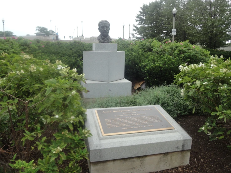 a statue in a garden with bushes