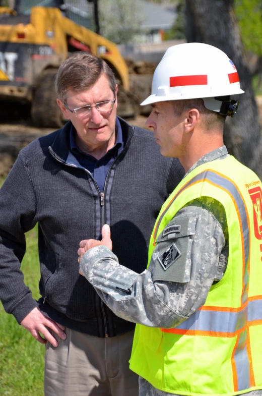 two men in safety vests standing near each other