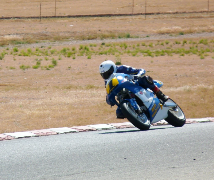 a man riding on the back of a motorcycle down a curvy road