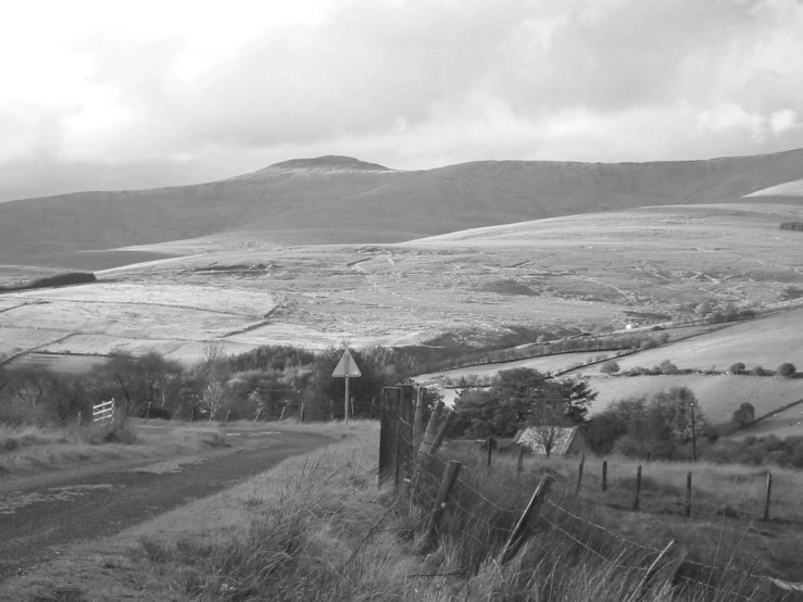 black and white image of mountains with a trail to the top