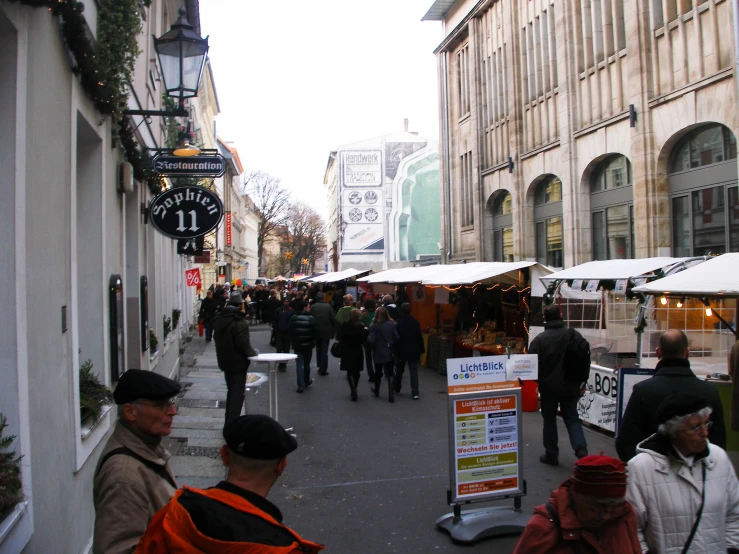 an outdoor market with many people walking around