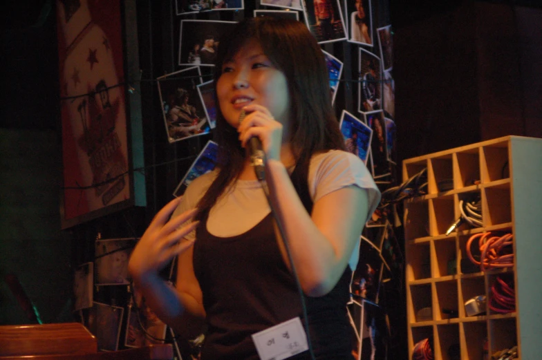 a female performer is standing while holding a microphone