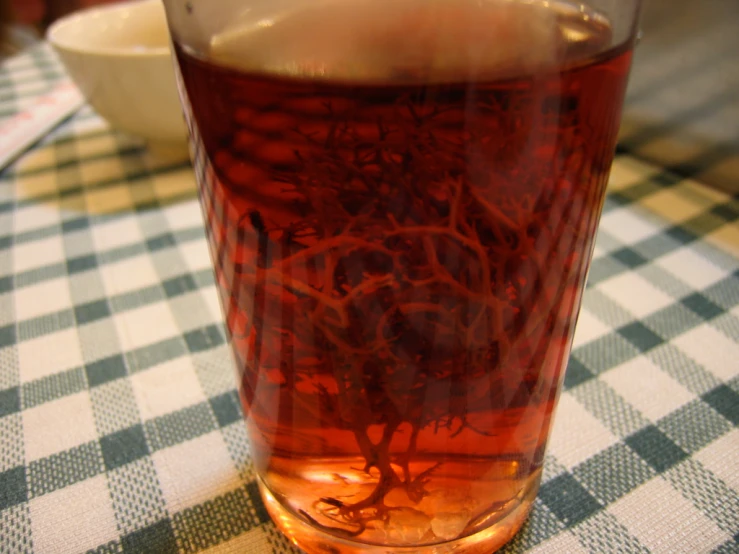 red liquid sitting on a table near a bowl