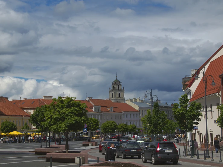 a street with several cars and a clock tower in the background