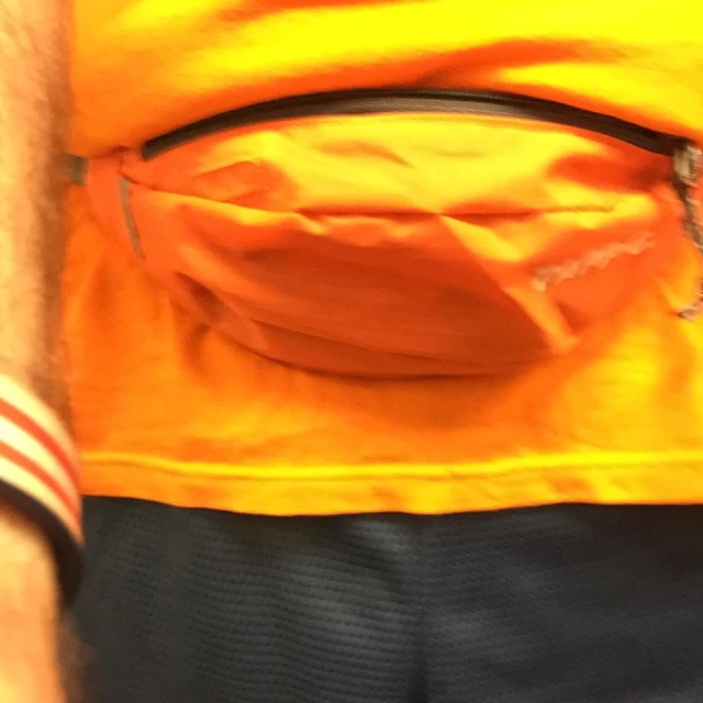 the bottom view of a orange backpack on a man