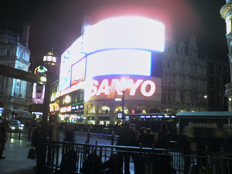 a busy city at night with people standing around