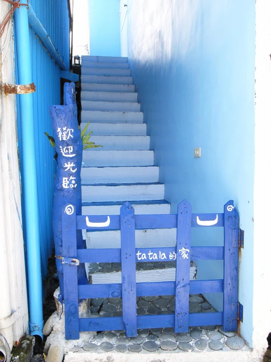 a stairway leading to the blue door in a chinese town
