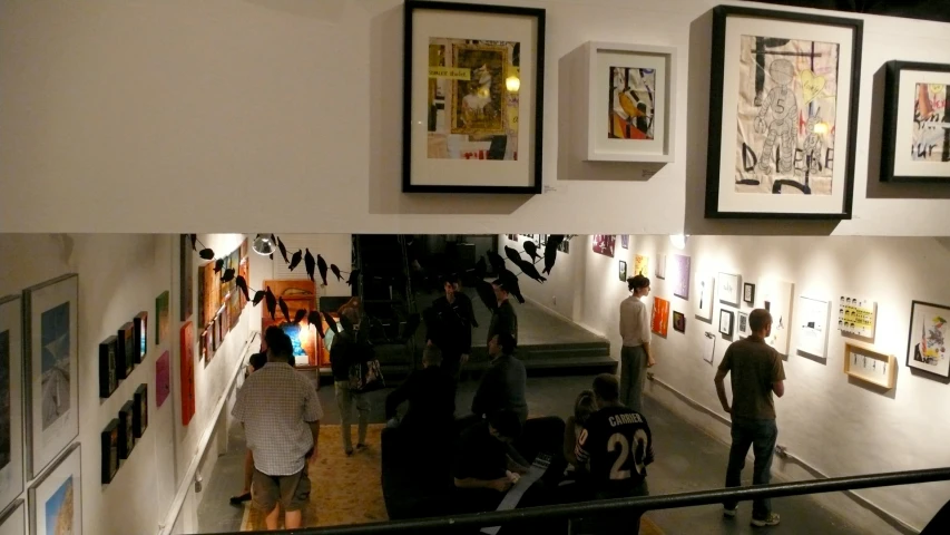 a group of people looking at various pographs on display