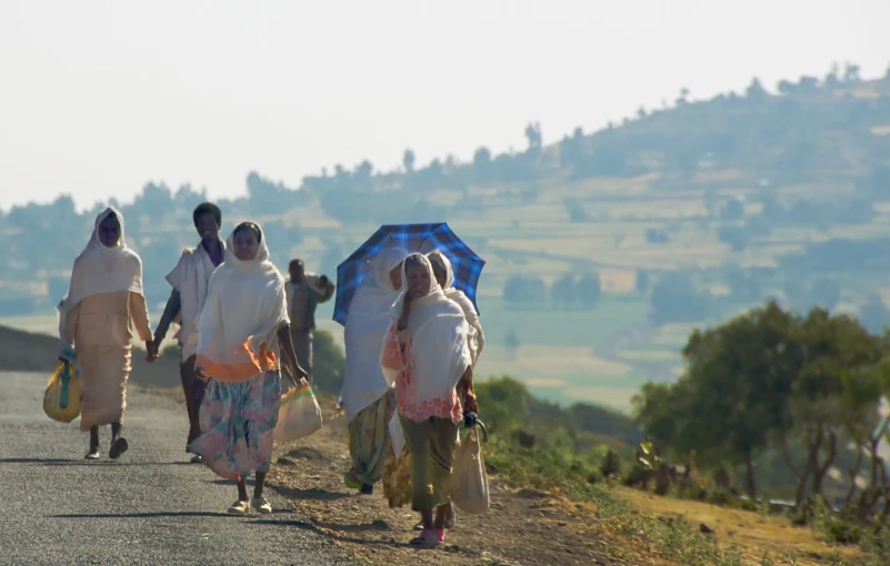 a couple of women walking down a dirt road