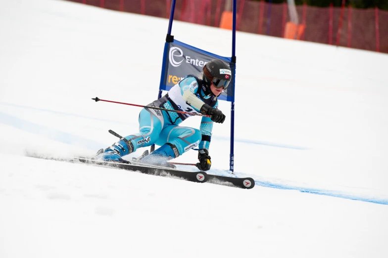 a skier in blue and white skiing down a course