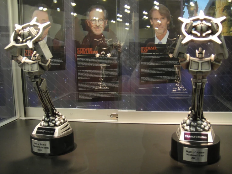 two trophies with statues standing in front of them