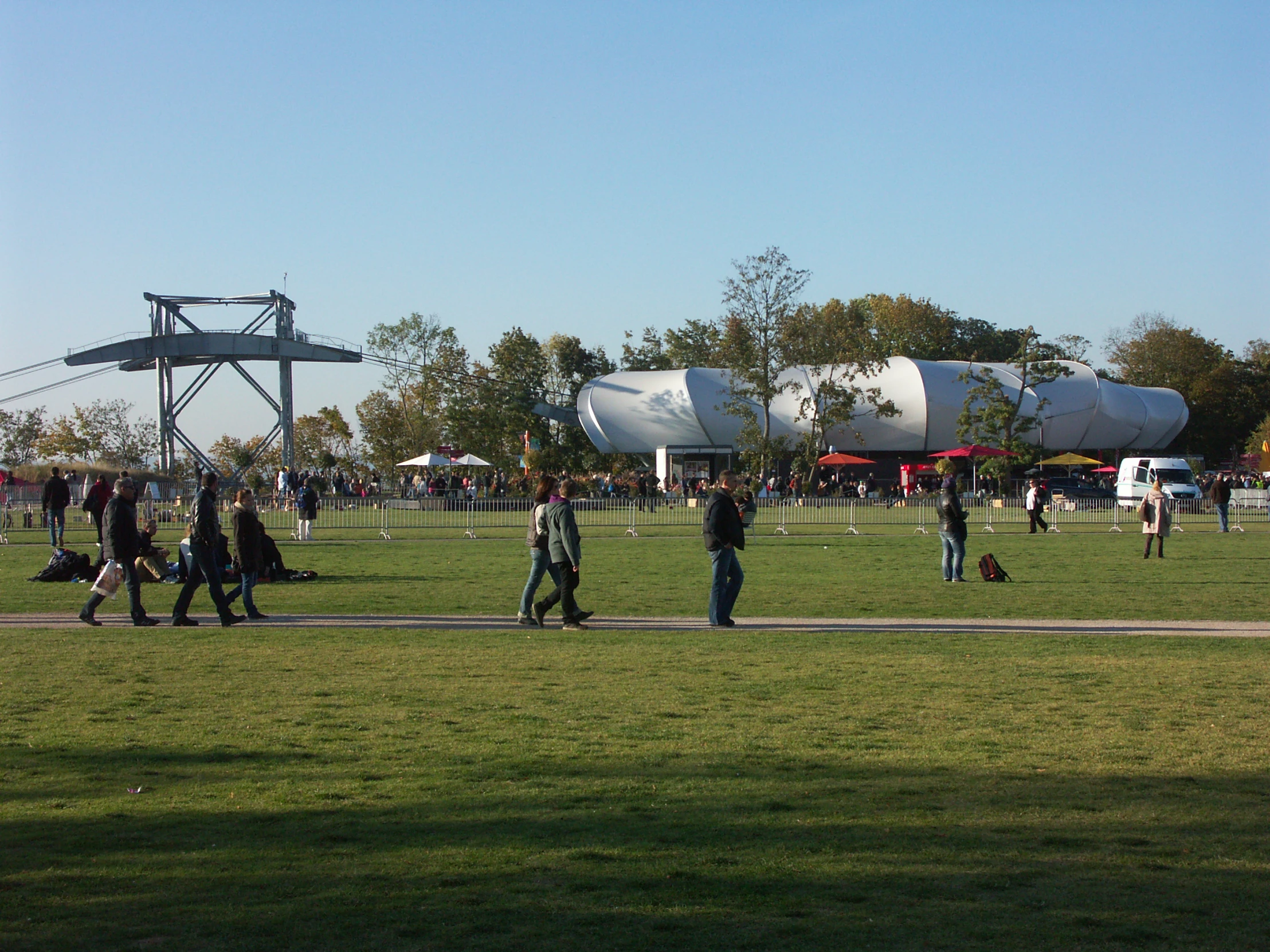people walking on grass in front of an airplane