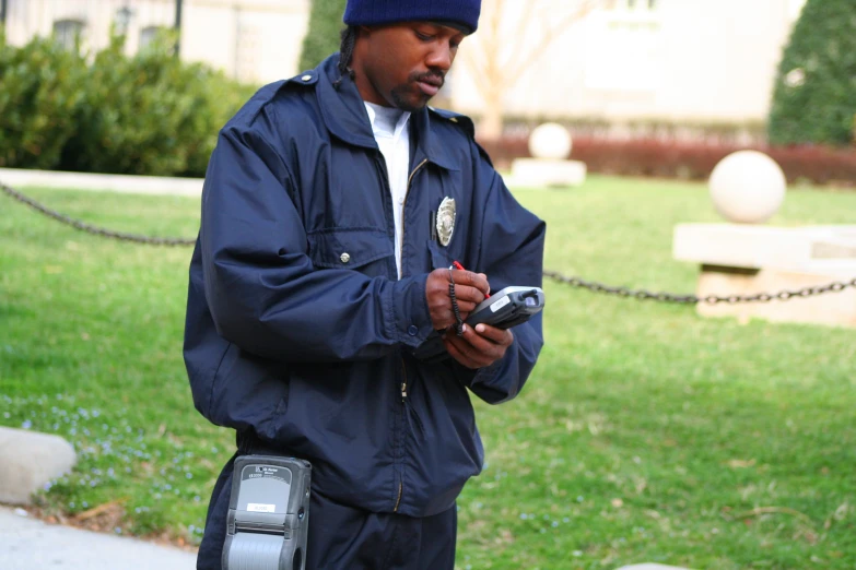 man in blue jacket using his cell phone on leash