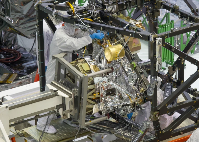 a worker working on a device with metal parts