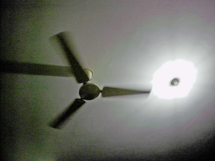 a ceiling fan glowing brightly on a dark night