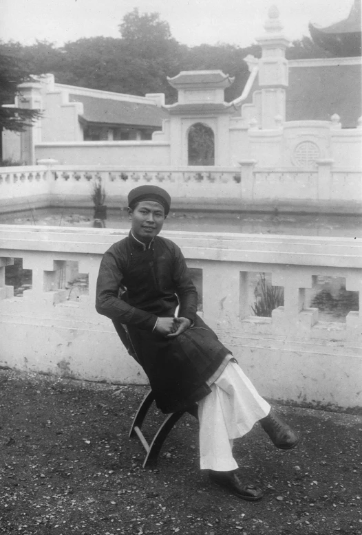 an asian woman poses for the camera in front of a large building
