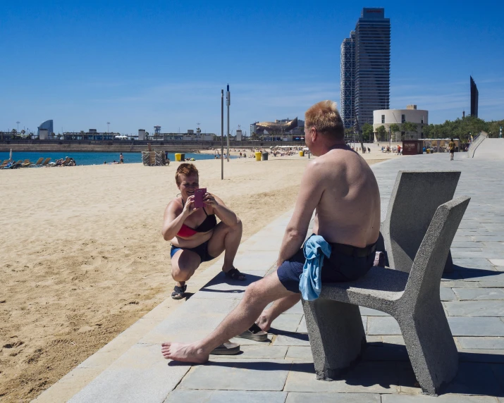 a man and woman sit on a park bench near a body of water