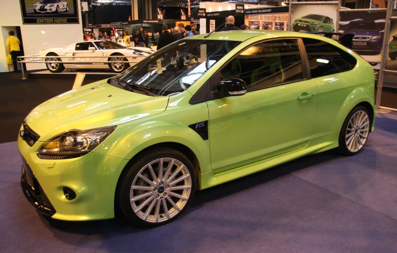 a lime green car sits in the middle of a show room