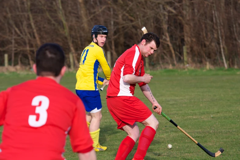 a man wearing red and white is playing hockey