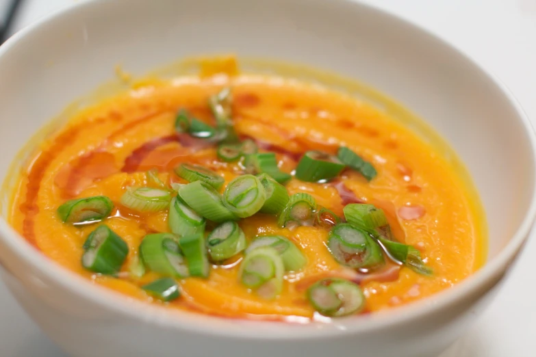 a white bowl filled with carrot and sauce