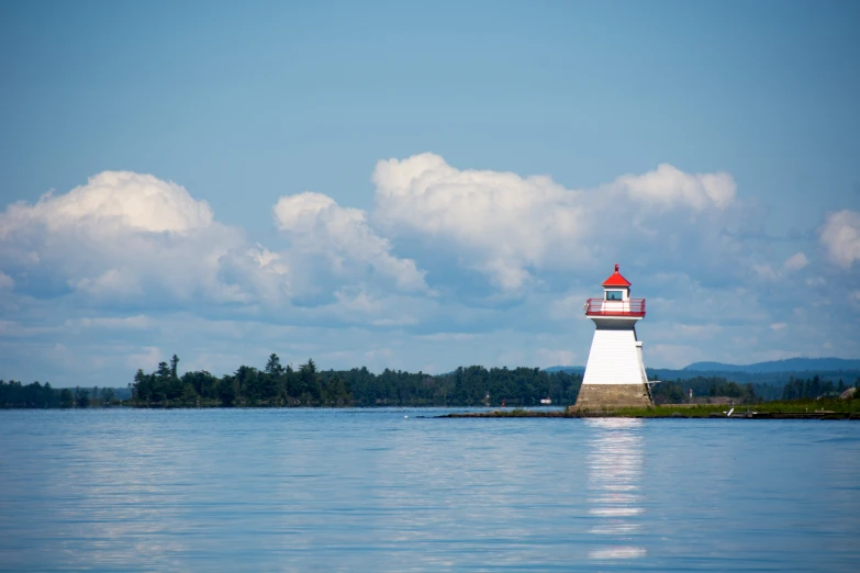 a small lighthouse on the edge of a small lake