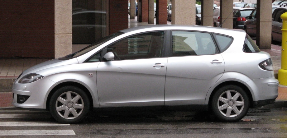 the silver smart car is parked in the parking lot