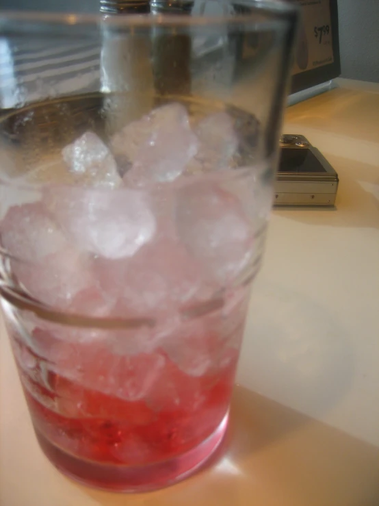 a glass filled with ice sitting on top of a table