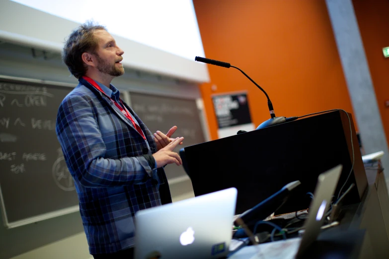 a man at a podium talking at a conference