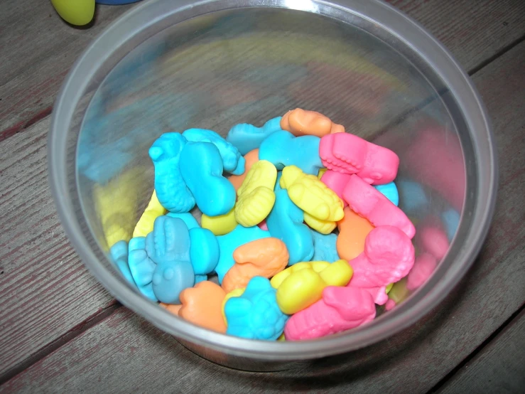 a bowl full of blue, pink and yellow elephants