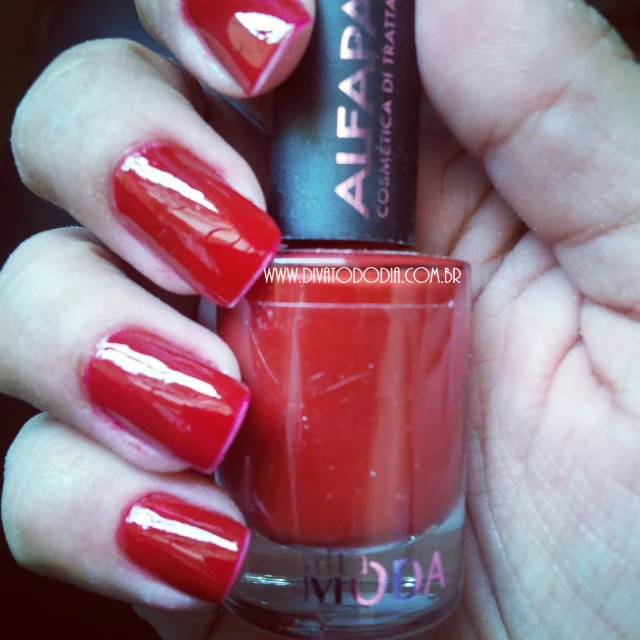 a red manicure with shiny chrome accents on it