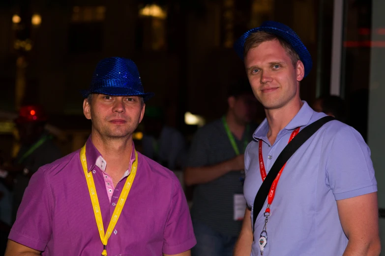 two men wearing blue hats at an event