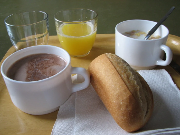 a breakfast plate with a bagel, coffee and orange juice