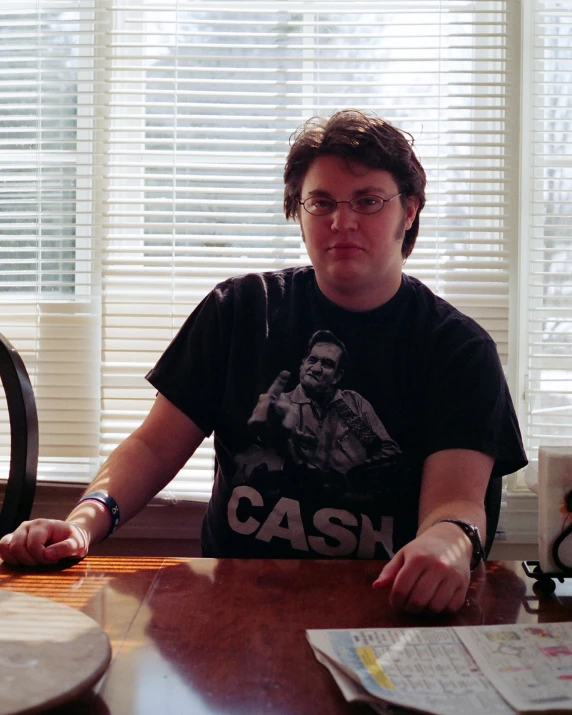 a man sitting at a table in front of a piece of pizza